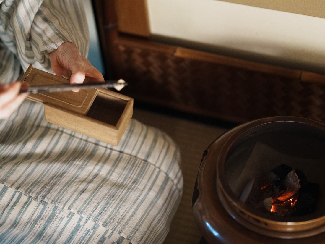 火箸で炭を継ぐ手